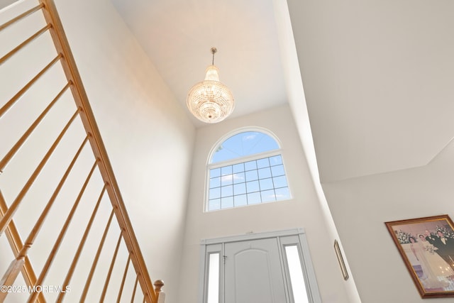 foyer entrance featuring a towering ceiling and a notable chandelier