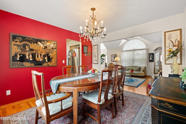 dining room featuring vaulted ceiling, a chandelier, wood finished floors, and baseboards