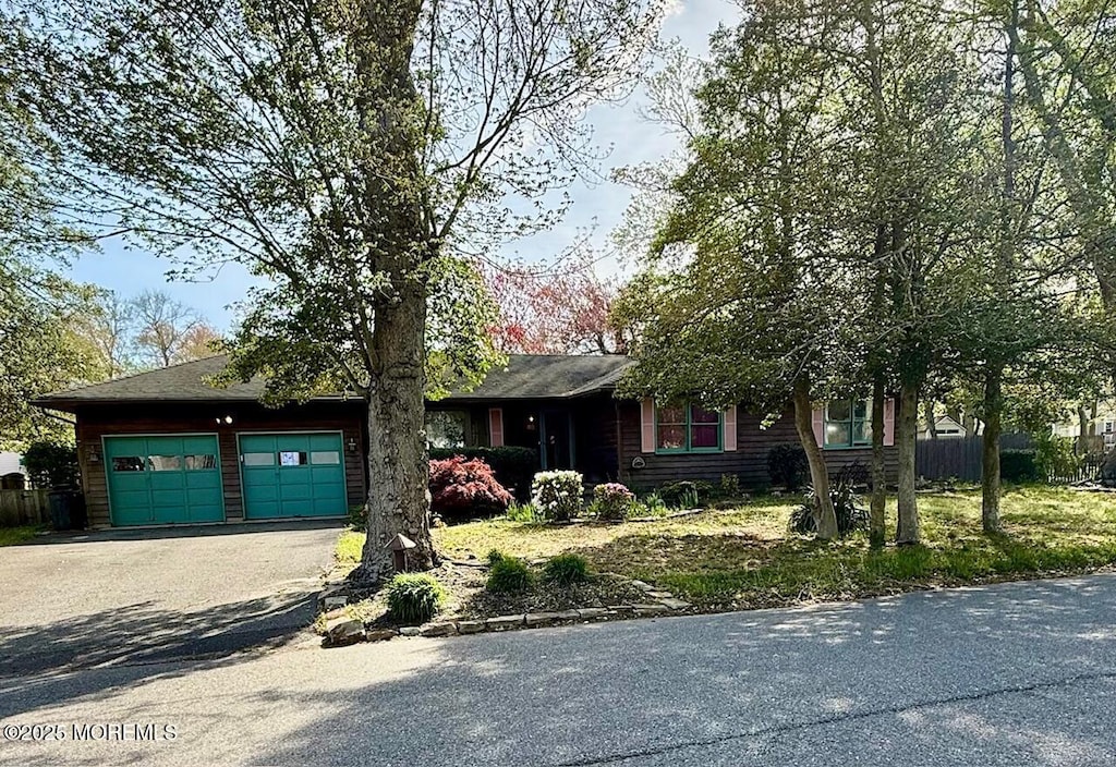 ranch-style house featuring an attached garage and aphalt driveway
