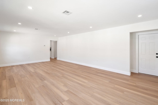 empty room with baseboards, light wood finished floors, recessed lighting, and visible vents