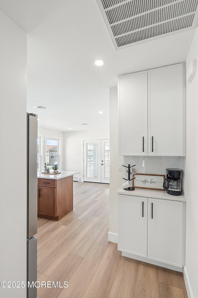 bar featuring freestanding refrigerator, recessed lighting, baseboards, light wood-type flooring, and visible vents