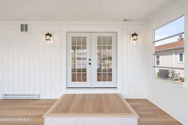 property entrance with cooling unit, visible vents, french doors, and a baseboard radiator