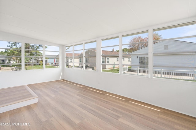 unfurnished sunroom featuring wood finished floors and vaulted ceiling