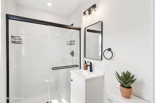 bathroom with toilet, a shower stall, and vanity