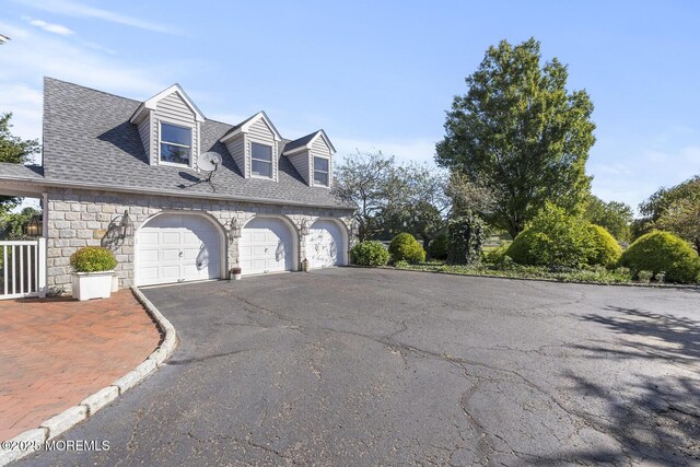 18 Schoolhouse Rd, Cream Ridge, NJ 08514 - view of side of home featuring a shingled roof, an attached garage, aphalt driveway, and stone siding