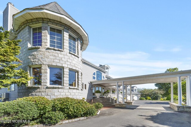 18 Schoolhouse Rd, Cream Ridge, NJ 08514 - view of side of property featuring a carport, stone siding, and aphalt driveway