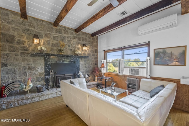 18 Schoolhouse Rd, Cream Ridge, NJ 08514 - living room with beam ceiling, a wall mounted air conditioner, wood-type flooring, a stone fireplace, and heating unit