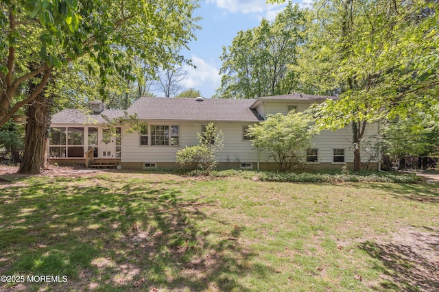 back of house featuring a yard and a sunroom