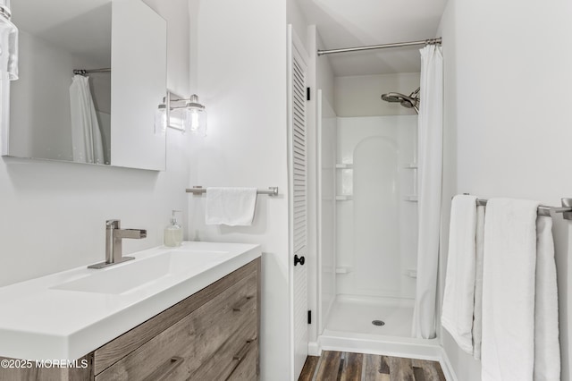 bathroom with vanity, curtained shower, and wood finished floors