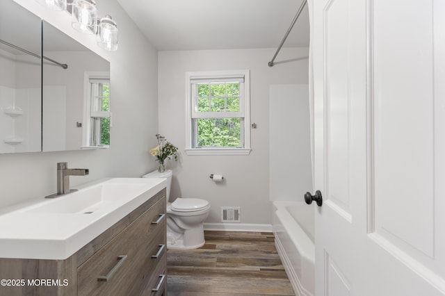 full bath with visible vents, wood finished floors, vanity, baseboards, and toilet