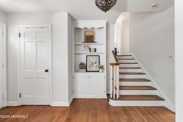 stairway featuring baseboards and wood finished floors