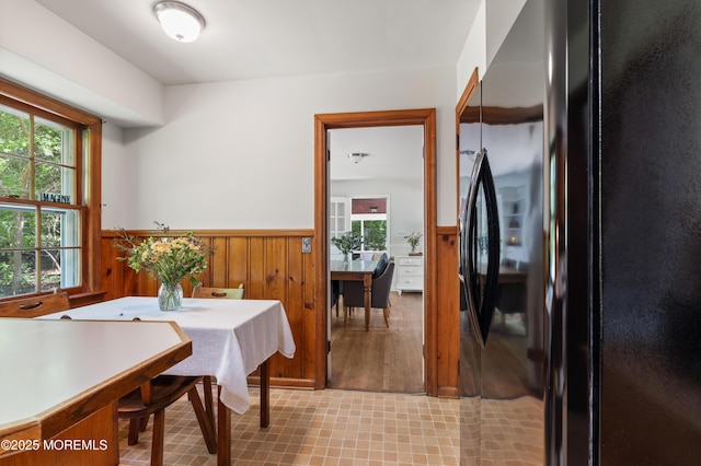dining space with a wainscoted wall and wood walls
