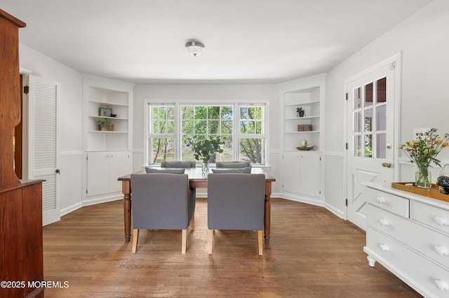 dining space featuring built in features and wood finished floors