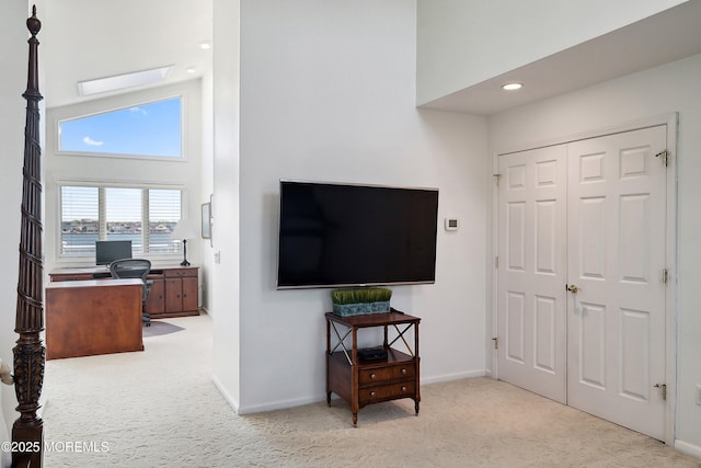 interior space with baseboards, recessed lighting, and a towering ceiling