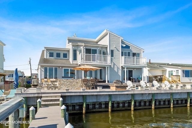 rear view of house with a patio, a water view, and a balcony
