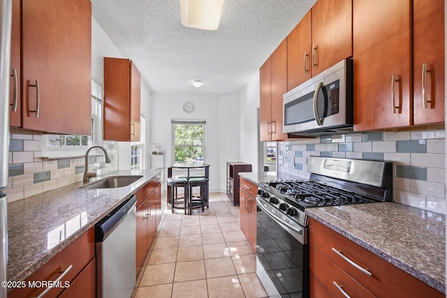 604 Gaitway Ct, Freehold, NJ 07728 - kitchen featuring decorative backsplash, brown cabinetry, appliances with stainless steel finishes, a sink, and dark stone countertops