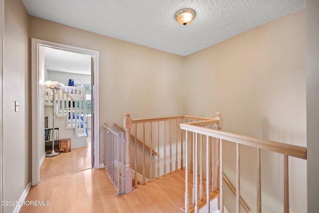 604 Gaitway Ct, Freehold, NJ 07728 - hallway with a textured ceiling, wood finished floors, and an upstairs landing