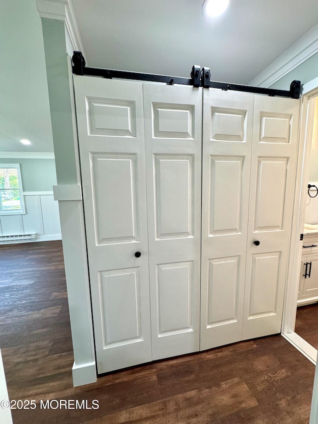 room details featuring a baseboard heating unit, ornamental molding, and wood finished floors