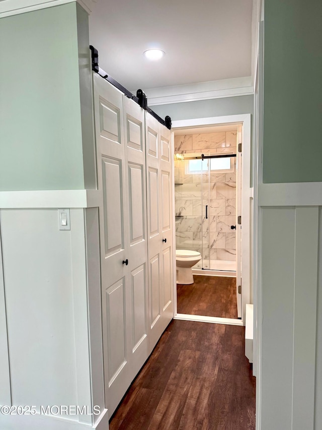 corridor with wainscoting and dark wood-style flooring