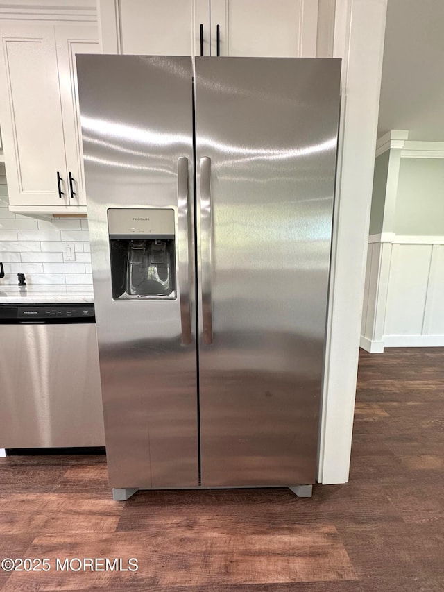 kitchen with tasteful backsplash, stainless steel appliances, dark wood finished floors, and white cabinetry