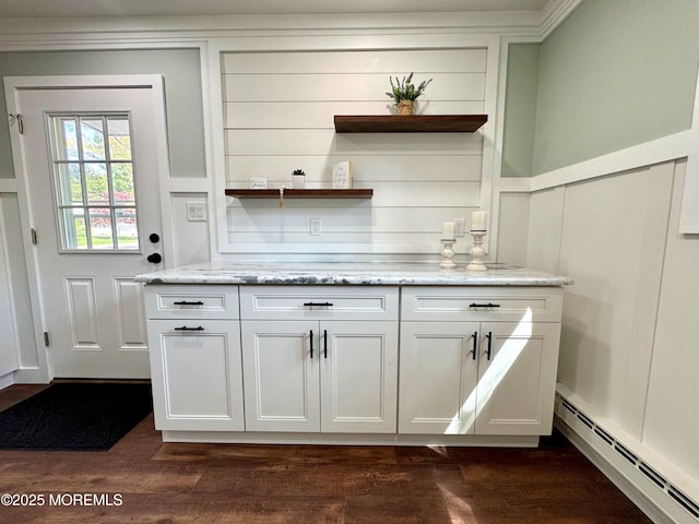 bar with a decorative wall, ornamental molding, a baseboard heating unit, and dark wood-type flooring