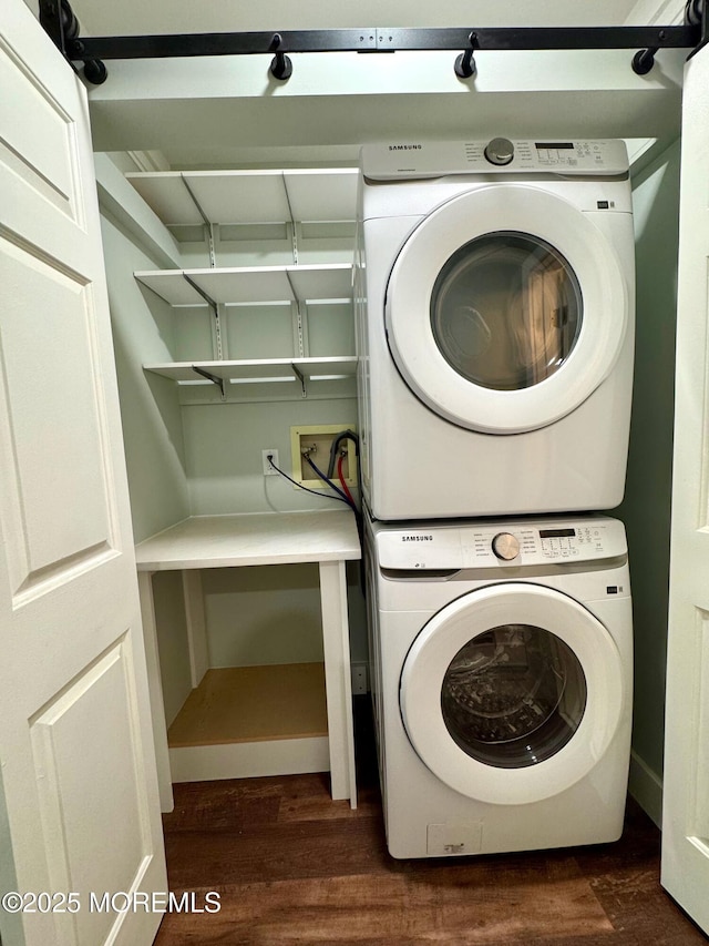 washroom with dark wood-style flooring, laundry area, and stacked washer and clothes dryer