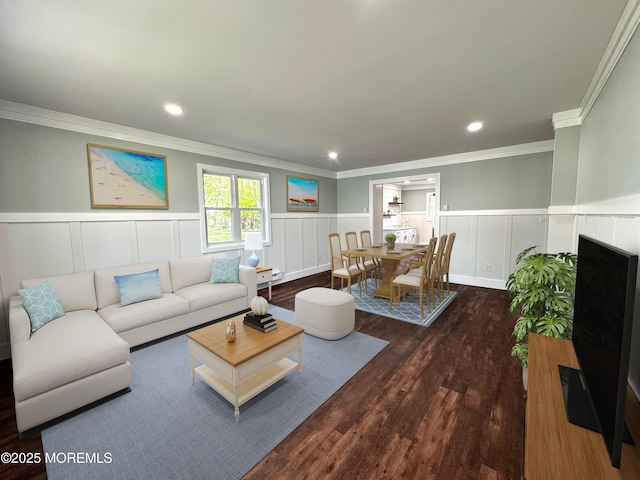 living area with a wainscoted wall, ornamental molding, a decorative wall, and wood finished floors