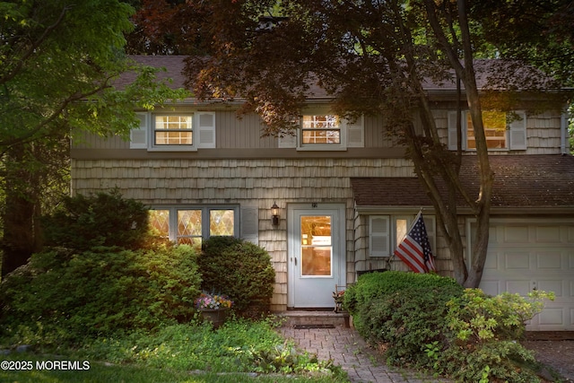 view of front of house featuring a garage and a shingled roof