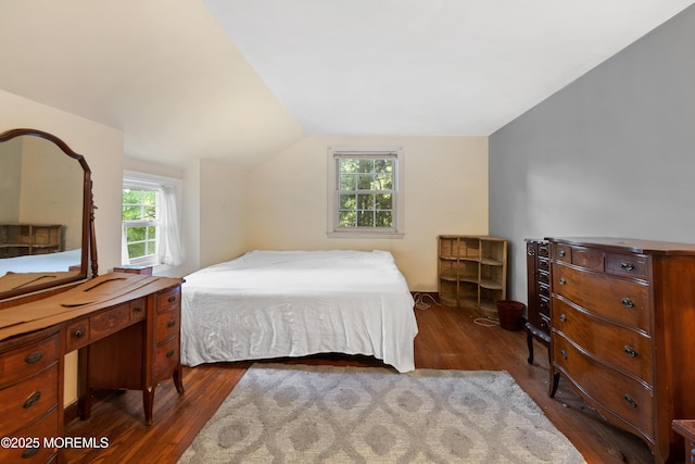 bedroom with dark wood finished floors and vaulted ceiling