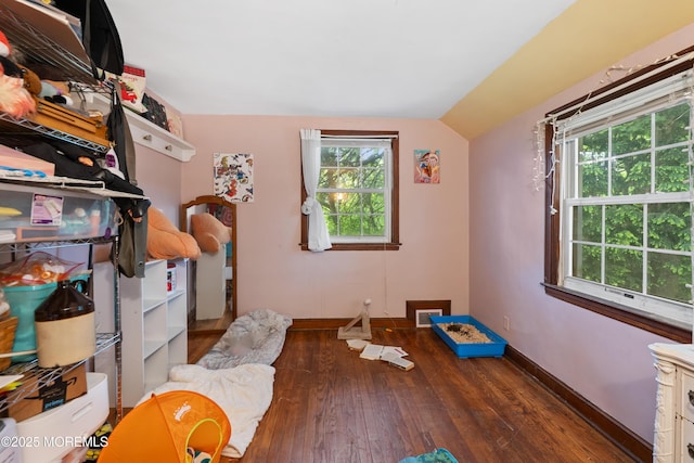 bedroom with lofted ceiling, wood-type flooring, and baseboards