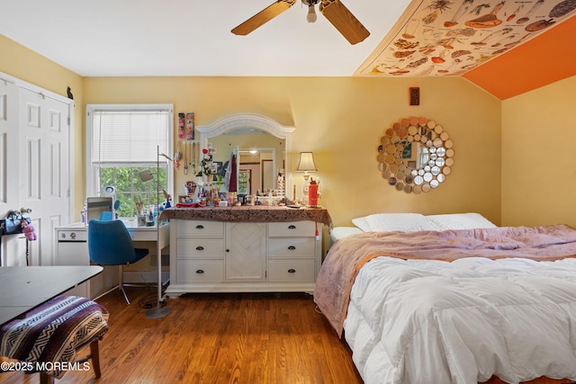 bedroom featuring dark wood-style floors, a closet, ceiling fan, vaulted ceiling, and an office area