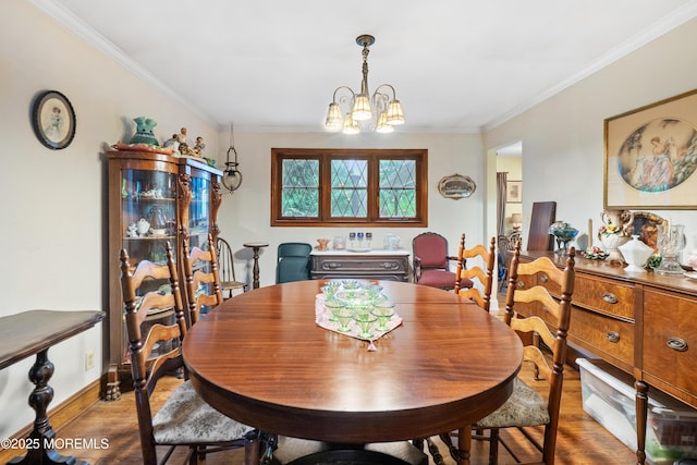 dining space featuring wood finished floors, a chandelier, and ornamental molding