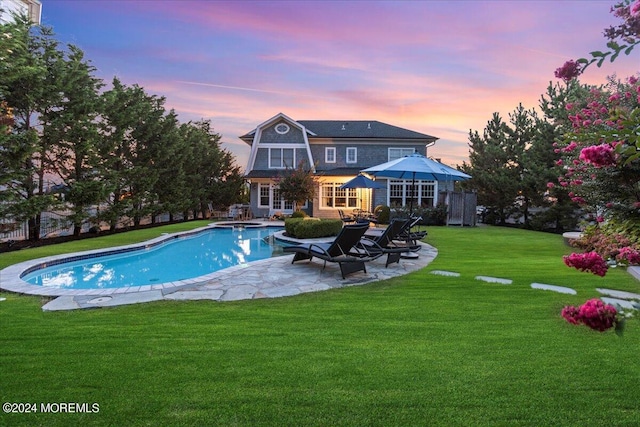 pool featuring a lawn and a patio area