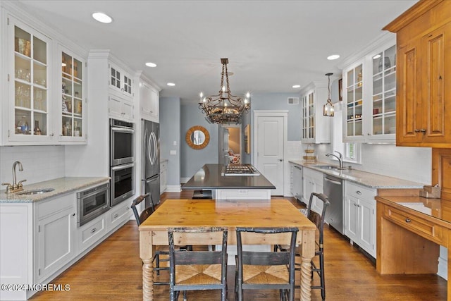 kitchen featuring a center island, a sink, backsplash, and stainless steel appliances