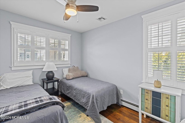 bedroom with ceiling fan, visible vents, wood finished floors, and a baseboard radiator