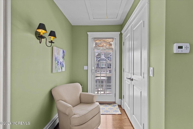 living area featuring baseboards, attic access, and wood finished floors