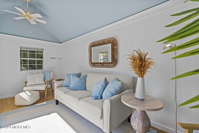 living area with baseboards, ceiling fan, wood finished floors, and lofted ceiling