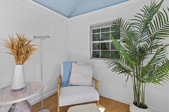 living area featuring baseboards, vaulted ceiling, and wood finished floors