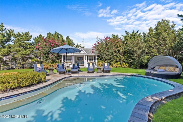 outdoor pool featuring a lawn, an outdoor structure, and a patio area