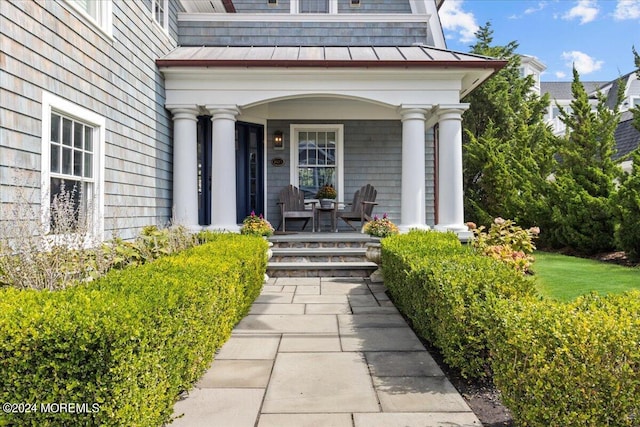 property entrance featuring a standing seam roof and a porch