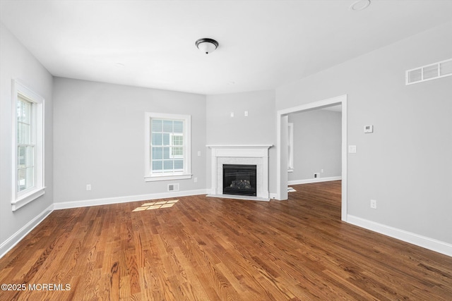 440 Ellisdale Rd, Chesterfield, NJ 08515 - unfurnished living room featuring visible vents, a fireplace with flush hearth, baseboards, and wood finished floors