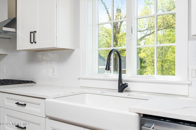 440 Ellisdale Rd, Chesterfield, NJ 08515 - kitchen featuring wall chimney range hood, tasteful backsplash, stainless steel dishwasher, a sink, and white cabinetry