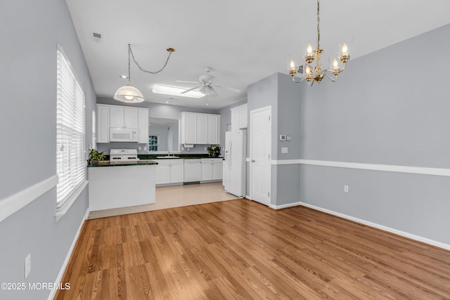 21 Edgeworth Cir, Manchester, NJ 08759 - kitchen with dark countertops, white appliances, white cabinetry, a sink, and ceiling fan with notable chandelier