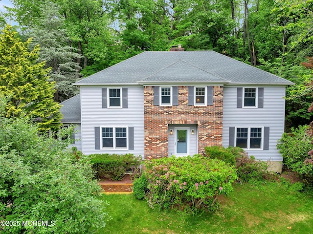 9 Berkshire Ct, Holmdel, NJ 07733 - view of front facade with a chimney, roof with shingles, view of scattered trees, and a front yard
