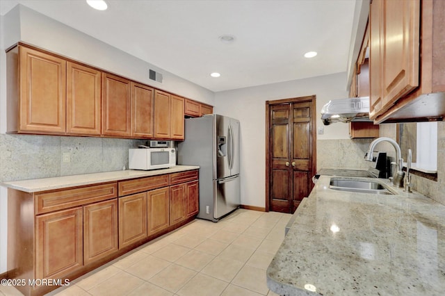 9 Berkshire Ct, Holmdel, NJ 07733 - kitchen with stainless steel refrigerator with ice dispenser, a sink, white microwave, decorative backsplash, and brown cabinetry
