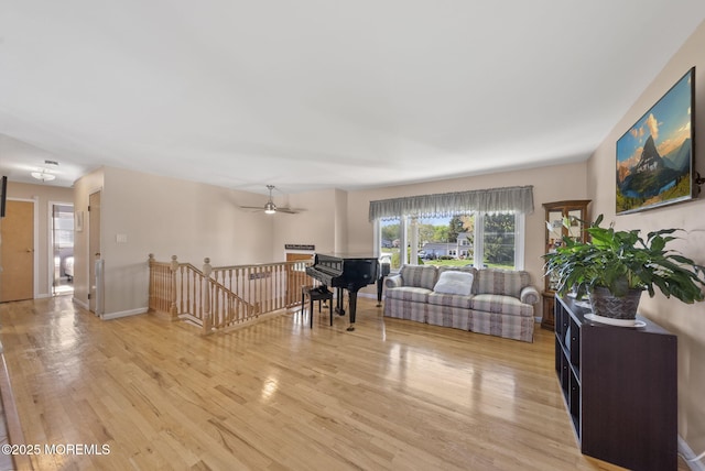 living room with a ceiling fan and light wood-type flooring