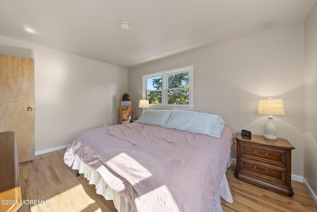 bedroom featuring baseboards and light wood-style floors