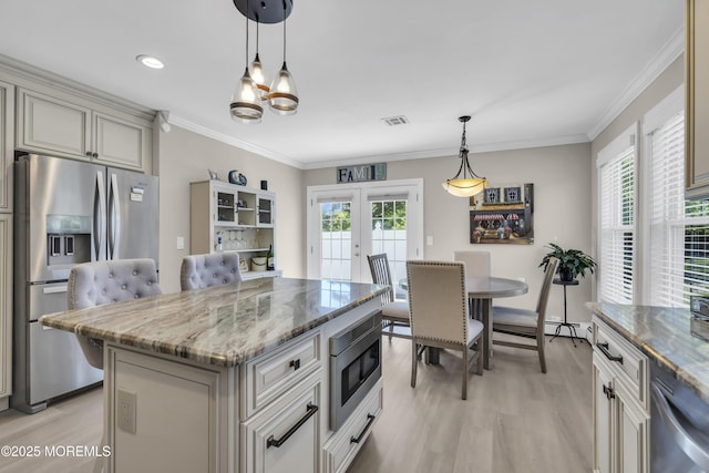 kitchen featuring stainless steel appliances, light wood finished floors, healthy amount of natural light, ornamental molding, and recessed lighting