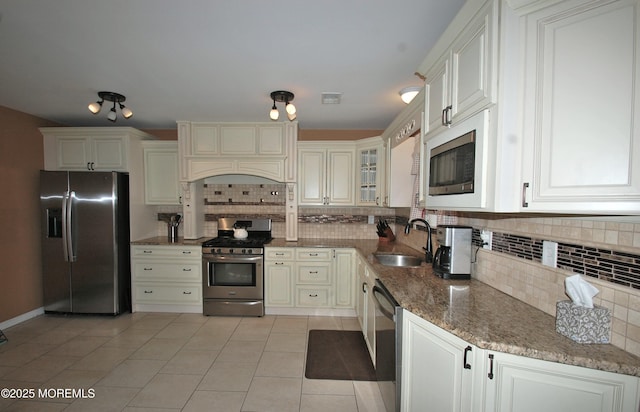 711 Edmunds Ave, Union Beach, NJ 07735 - kitchen featuring a sink, dark stone countertops, appliances with stainless steel finishes, and backsplash