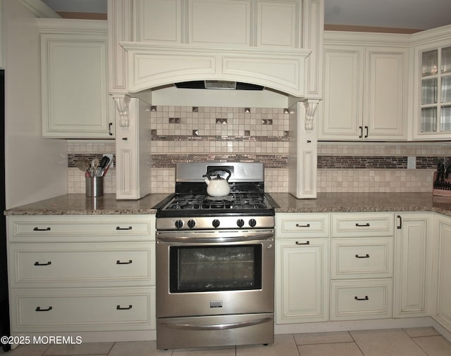 711 Edmunds Ave, Union Beach, NJ 07735 - kitchen featuring dark stone counters, decorative backsplash, stainless steel gas range oven, and glass insert cabinets